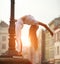 Sport athletic gymnast girl doing workout stretching on street of the old city in summer