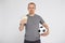 Sport, betting, success, win, finance and people concept - happy young man with euro money and  soccer ball over grey background