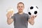 Sport, betting, success, win and money concept - cheerful young man with euro money and  soccer ball over grey background