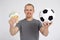 Sport, betting, success, win and money concept - happy young man with euro money and  soccer ball over grey background