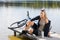 Sport biking young woman sitting by lake