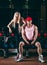 Sport, bodybuilding, weightlifting, lifestyle and people concept - Young beautiful couple in stylish clothes sitting a