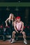 Sport, bodybuilding, weightlifting, lifestyle and people concept - Young beautiful couple in stylish clothes sitting a