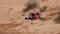 Sport car for off road extreme racing gets over the difficult part of the route during the rally raid in sand.
