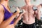 Sport - couple is exercising with barbell in gym