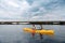 Sport couple holding red and yellow paddles rowing in canoe