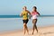 Sport couple jogging on the beach