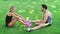 Sport couple resting on grass after outdoor workout. Young man and woman