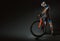 Sport. Cyclist carry a bike on black background.