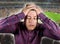 Sport emotion conceptual portrait of nervous and dejected soccer supporter man and football pitch background gesturing desperate
