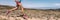 Sport exercise fitness female athlete runner running on trail run race in desert panorama banner. Closeup of legs and