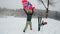 Sport fan man waving an Italian flag, another fan rushes and pushes him into the snow