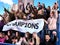 Sport fans holding champion banner on tribunes