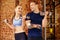 Sport fit couple at gym. work in pairs with dumbbells.