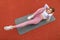 Sport and fitness concept outdoors. Top view of pretty Caucasian blond sports woman in pink clothes, lying on the yoga