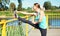 Sport and fitness concept - woman doing stretching exercise in city
