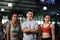 Sport and fitness concepts, young sports people and trainer in gym, man with crossed hands and two women fit sporty