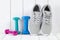 Sport and fitness symbols - sneakers, and colorful dumbbells on