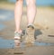 Sport footwear, sand footprints and legs close up