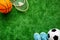 Sport games equipment on football field - balls, sneakers, rackets. Top view