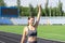 Sport girl doing stretching her arms. Fitness woman doing warm up exercises training in running stadium. Sport in open air and