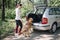 Sport girl getting dog in opened trunk