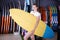 Sport girl surfer holding new surfboard in nautical store