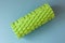 Sport green foam roller on blue background. Fitness background.