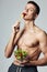 sport guy with naked pumped up body plate salad eating isolated background