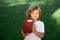 Sport kid. American football, rugby. Portrait of boy holding american football ball in park.