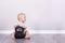 Sport is life. Happy laughing toddler sitting on the floor with kettlebell. Copy space