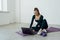 Sport and lifestyle concept. Smiling young woman doing yoga at home, follow course on laptop, sitting on floor mat