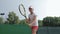 Sport lifestyle, professional athlete child girl plays at sports game and hitting racket on ball at professional red