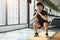 Sport man doing squat posture on yoga mat in fitness gym at condominium in urban. People lifestyles and Sport workout concept