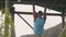 Sport man hanging on wooden crossbar training abs muscles outdoor. Male abs workout on horizontal bar. Back view athlete