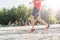 sport man with ripped athletic and muscular legs running downhill off road in jogging training workout