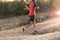 Sport man with ripped athletic and muscular legs running uphill off road in jogging training workout