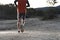 Sport man with ripped athletic and muscular legs running uphill off road in jogging training workout