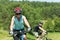 Sport mountain couple biking uphill sunny meadows