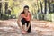 Sport runner woman tying her shoe sneaker laces smiling happy ready for running and jogging workout at city forest park