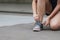 Sport sneakers footwear young woman knelt down do up shoelaces. Ready running shoes in sport exercise jogging person. Close up