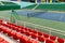 Sport stadium with several rows of spectator seating and tennis court at sport stadium or performance venue.