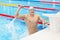 Sport swimmer winning. Man swimming cheering celebrating victory success smiling happy in pool wearing swim goggles and