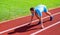 Sport tips from professional runner. Man athlete runner stand low start position stadium path. Make effort for victory