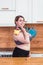 Sport with unhealthy food. combination of active life with fast food. close up photo. fat woman showing kettlebell and hot dog