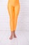 Sport wear fashion. orange. practicing in ballet studio. woman in orange leggings on legs. dancing ballet position of