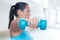 Sport woman with blue dumbbell doing exercise outdoor, only dumb bell and hand in focus