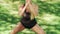 Sport woman doing squat exercise in city park at workout outdoor. Fitness woman