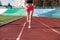 Sport. Woman fitness legs running on stadium. Close up of feet of a runner. Woman fitness jog workout wellness concept. Athlete