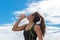 Sport woman holding a water bottle after exercise,back ground blue sky.